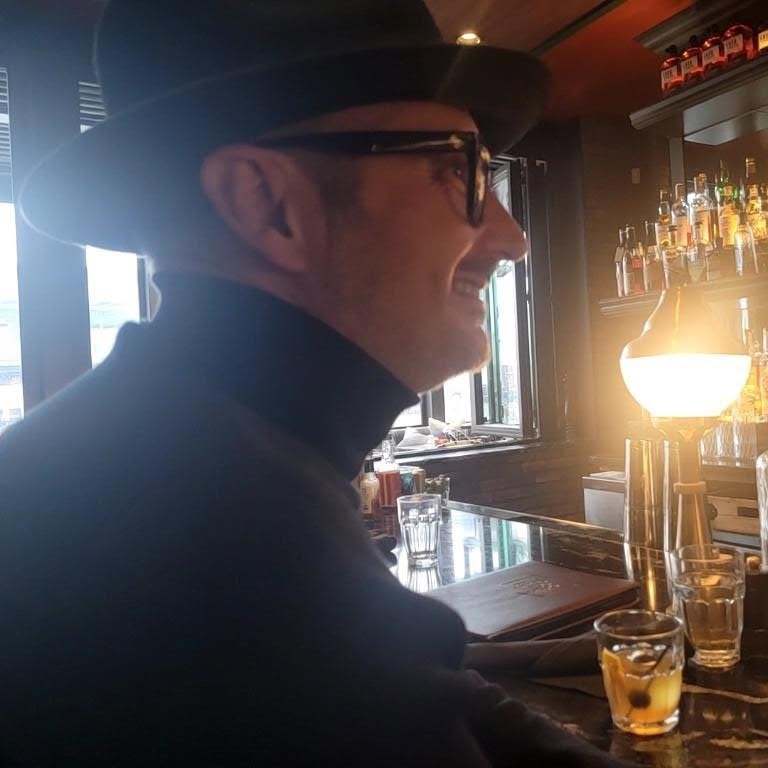 Thomas Dishaw in a black fedora and glasses